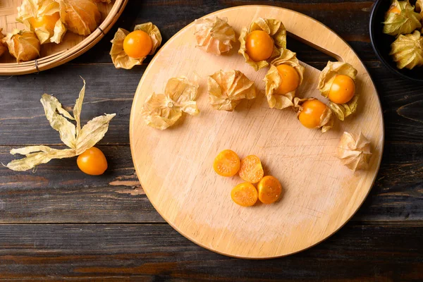 Cape gooseberry or golden berry (Physalis peruviana) on wooden background, Healthy tropical fruit, Table top view