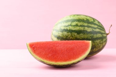 Pembe arka planda karpuz, yaz mevsiminde tropik meyve.
