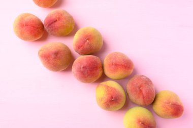 Pembe arka planda şeftali meyvesi, düz, üst görünüm