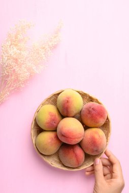 Şeftali meyvesi sepette, pembe arka planda, Top view