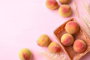 Pembe arka planda sepette Asya şeftali meyvesi, Üst Manzara