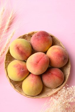 Pembe arka planda sepette Asya şeftali meyvesi, Üst Manzara