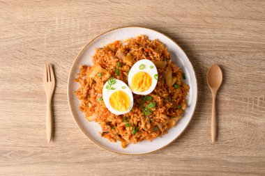 Kore kimchi pilavı ve ahşap masada haşlanmış yumurta.