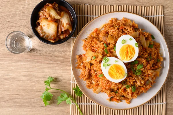 Kore kimchi pilavı ve ahşap masada haşlanmış yumurta.