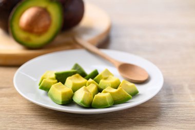 Dilimlenmiş avokado meyvesi tabakta yemeye hazır.