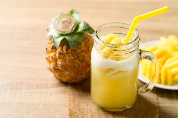 Pineapple smoothie and fresh pineapple fruit on wooden table, Summer drink