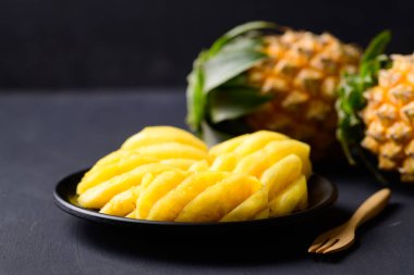 Siyah arka planda dilimlenmiş ananas meyvesi, yaz mevsiminde tropik meyve.