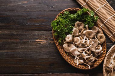 Fresh edible mushroom (Lentinus squarrosulus) in basket on wooden background, Organic food ingredients in seasonal, Table top view