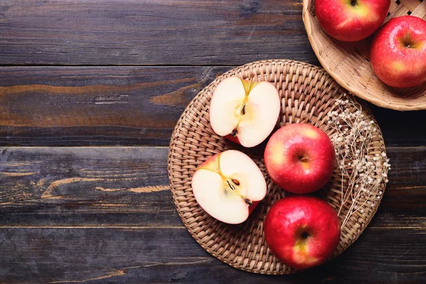 Ahşap zemin üzerinde kırmızı elma meyvesi, masa üstü görünümü