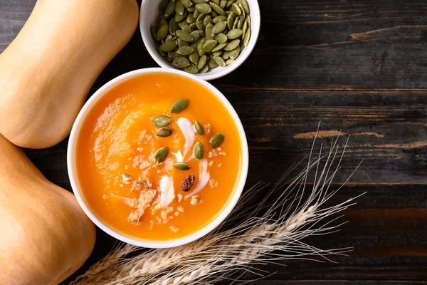 Butternut squash pumpkin soup in bowl on wooden background, Homemade food in autumn season