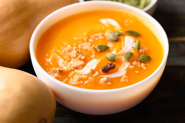 Butternut squash pumpkin soup in bowl on wooden background, Homemade food in autumn season