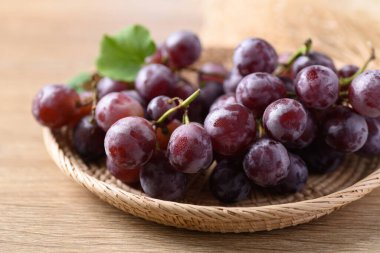 Ahşap zemin üzerinde kırmızı üzüm sepeti
