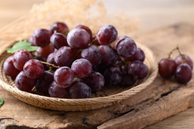 Ahşap zemin üzerinde kırmızı üzüm sepeti