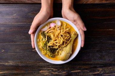 Kuzey Tayland yemekleri (Khao Soi), baharatlı körili şehriye çorbası, ahşap arka planda tavuklu tavuk çorbası, Tayland yemeği.