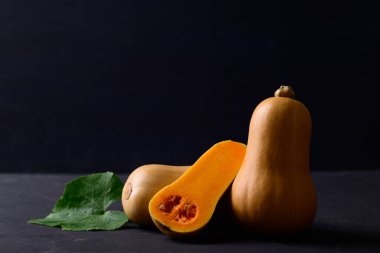 Siyah arka planda tereyağlı kabak ya da balkabağı, sonbahar mevsiminde sebzeler