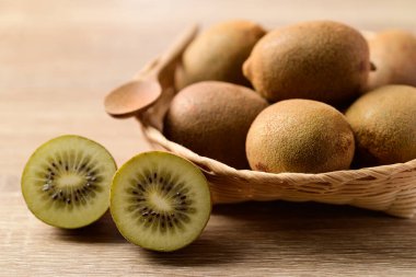 Tahta arka planda sepetteki taze altın kivi meyvesi.