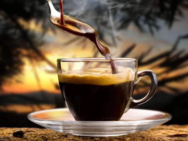 Kaffe ' het serveras i en liten kopp vid solnedgången — Stockfoto