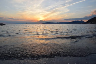 İnanılmaz ışıklar ve renkler, Liguria 'da denizin üstünde romantik günbatımı.