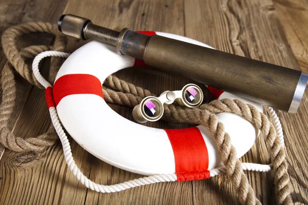 Lifebuoy with rope, telescope and binoculars — стоковое фото