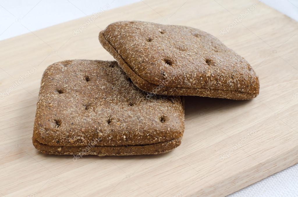 Two pieces of rye bread square shape and rye bran and muesli on plates