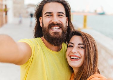 Tatilde mutlu bir çift kameraya bakan akıllı telefonlu komik bir selfie çeker - yaşam tarzı ve paylaşım konsepti