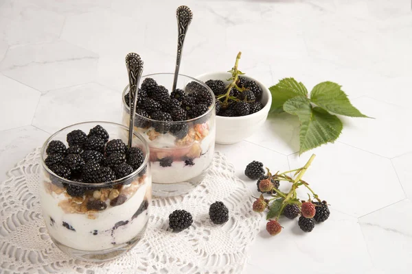 Dantelli peçetede böğürtlenli cheesecake ile iki bardak.