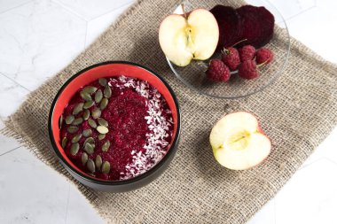 Elma pancarı ve ahududulardan yapılmış bir kase meyve püresinin en üst görüntüsü..