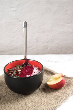 Bir kase elma ve pancar suyu ve kaşık. Sağlıklı vejetaryen tatlı..