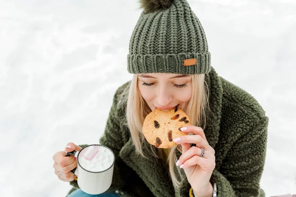 冬を屋外で楽しむ美しい若い女の子 可愛い女性はココアを飲み 雪の森で楽しんでいます — ストック写真