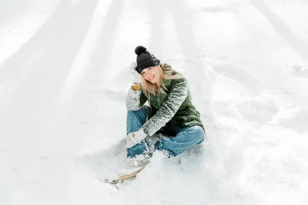 かなり若い金髪の女性は 暖かく スカーフとミトンで身を包んだ 雪の中で楽しんでいる美しい女の子 — ストック写真