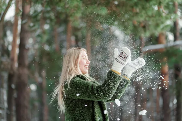 かなり若い金髪の女性は 暖かく スカーフとミトンで身を包んだ 雪の中で楽しんでいる美しい女の子 — ストック写真
