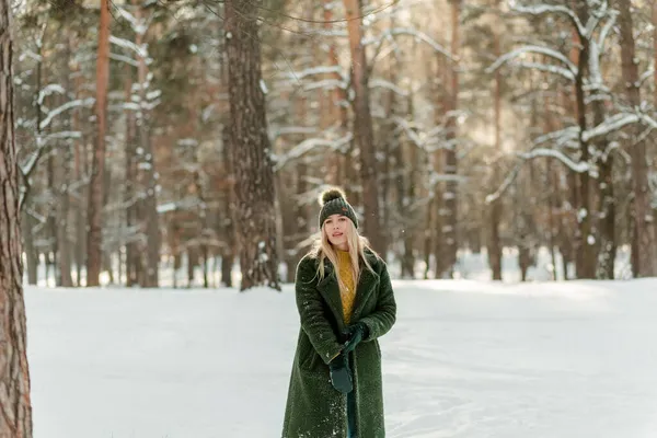 かなり若い金髪の女性は 暖かく スカーフとミトンで身を包んだ 雪の中で楽しんでいる美しい女の子 — ストック写真