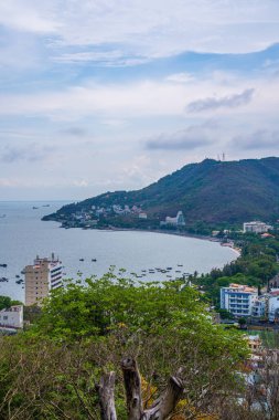 Yukarıdan Vung Tau panoramik kıyı manzarası, dalgalar, kıyı şeridi, sokaklar, hindistan cevizi ağaçları ve Vietnam 'daki Tao Phung dağı. Seyahat ve manzara konsepti.