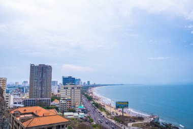 Yukarıdan Vung Tau panoramik kıyı manzarası, dalgalar, kıyı şeridi, sokaklar, hindistan cevizi ağaçları ve Vietnam 'daki Tao Phung dağı. Seyahat ve manzara konsepti.