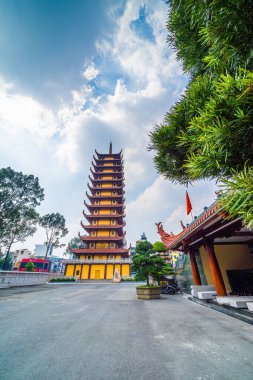 Ho Chi Minh şehri, Vietnam - 25 Aralık 2021: Quoc Tu Pagoda Vietnam 'da, Ho Chi Minh.Kızıl uzun Asya tapınağı Saigon' da mavi gökyüzü arka planında. Ho Chi Minh şehrinde ünlü bir pagoda. Seyahat ve din kavramı.