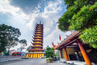 Ho Chi Minh şehri, Vietnam - 25 Aralık 2021: Quoc Tu Pagoda Vietnam 'da, Ho Chi Minh.Kızıl uzun Asya tapınağı Saigon' da mavi gökyüzü arka planında. Ho Chi Minh şehrinde ünlü bir pagoda. Seyahat ve din kavramı.