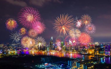 Kutlama. Vietnam 'ın Ho Chi Minh şehrinde (Saigon) havai fişeklerle gökyüzü aydınlandı. Güzel gece manzaralı şehir manzarası. Tatiller, yeni yılı ve Tet tatilini kutlamak.