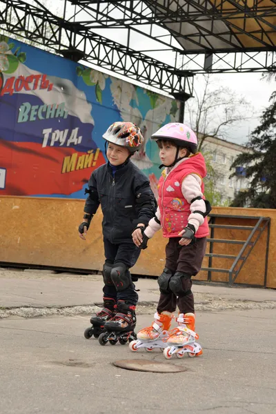 Mädchen und Junge rollen auf Rollen — Stockfoto