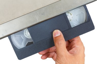Hand with video cassette in video player clipart