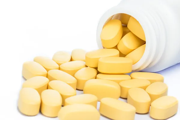 Sarı hapı bir ilaç şişesi dışarı dökülmesini