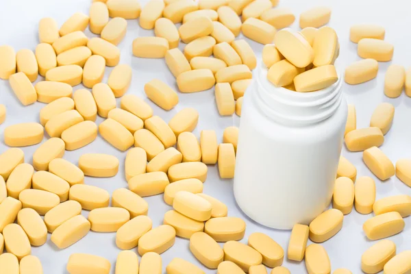 Żółte tabletki wysypują się z butelki medycyny — Zdjęcie stockowe