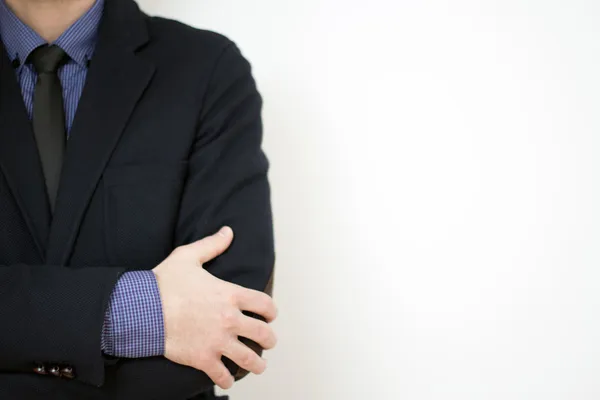 Businessman with hands folded against white background — ストック写真