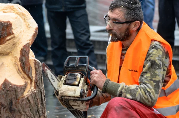 Artist carving wood with chainsaw during euromaidan in ukraine — Stock Photo, Image