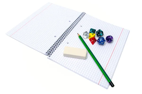 Set di quaderno, matita, gomma e dadi isolati su bianco — Foto Stock