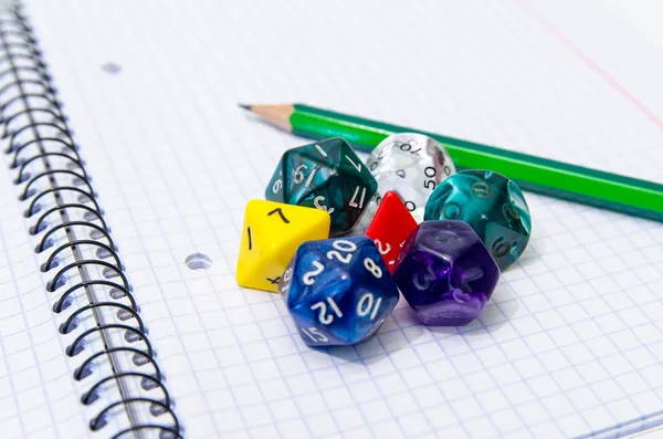 Set of open exercise book, pencil and dices — Stock Photo, Image