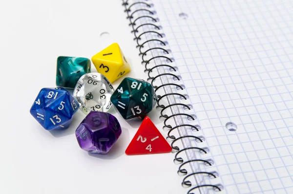 Role playing dices lying on exercise book — Stock Photo, Image