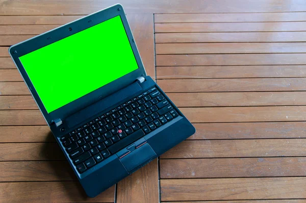 Open laptop, notebook with green screen lying on table — Stock Photo, Image