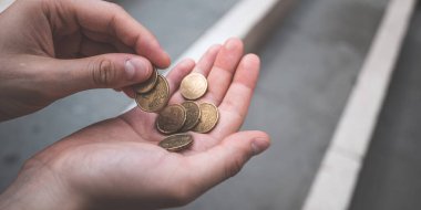 Sokakta avroyu tutan ve sayan iki kadın el.
