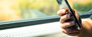 Trende telefonu kullanan adam.