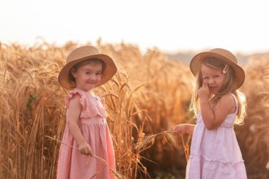 Hasır şapkalı ve pembe elbiseli iki kız kardeş buğday tarlasında koşuşturuyor. Kız arkadaşlar eğleniyor, çavdar viskisi topluyorlar. Sarı lastik çizmeli kız, diğeri çamurda yalınayak.